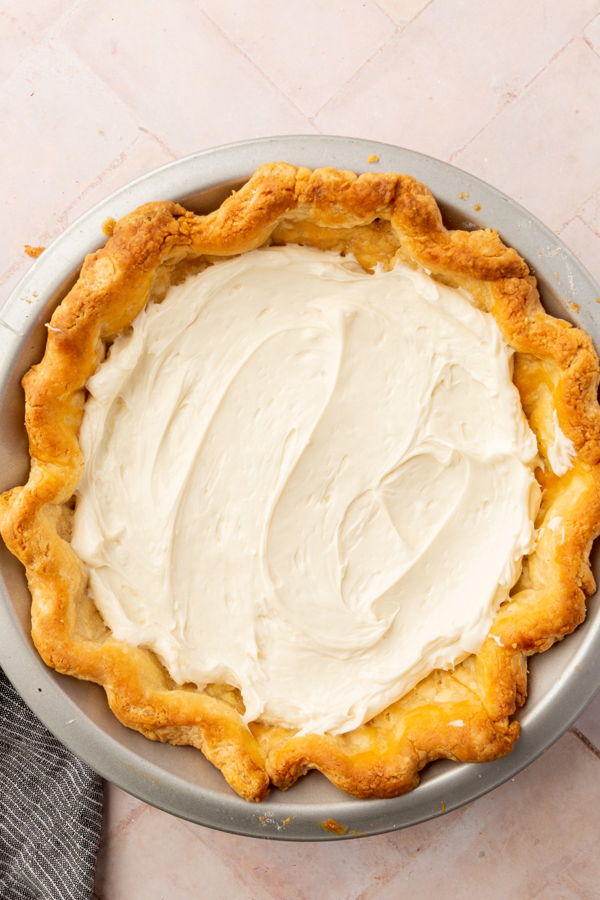 A baked gluten free pie crust spread with a thick layer of creamy white cream cheese filling.