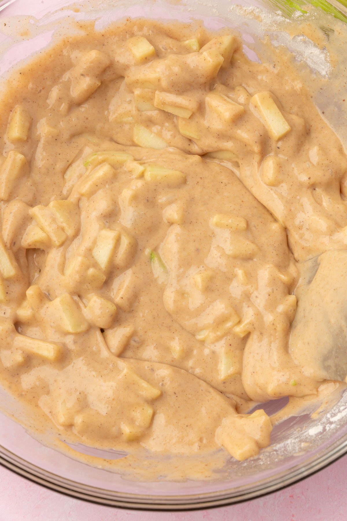 Gluten-free apple fritter batter after mixing, with chunks of apple visible throughout.