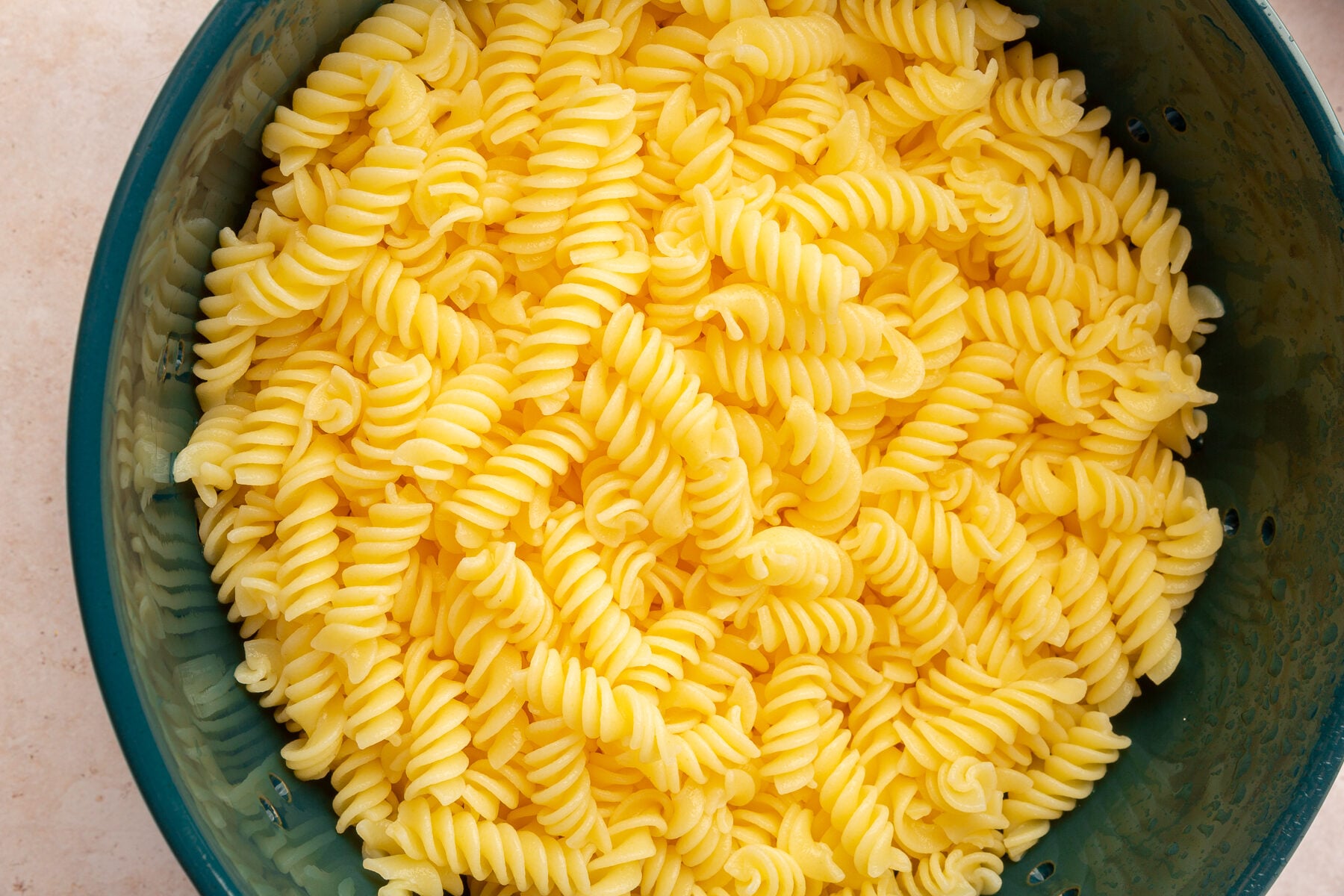 Gluten-free pasta in a large green bowl.