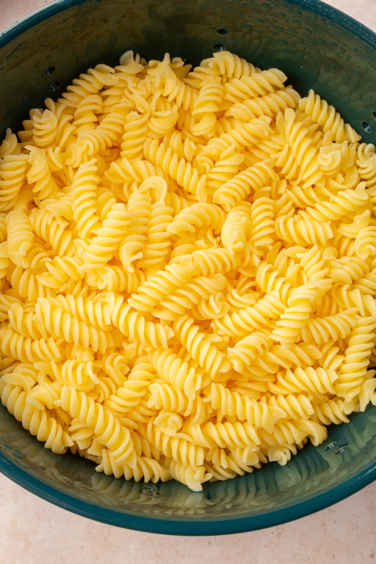 Gluten-free pasta in a large green bowl.
