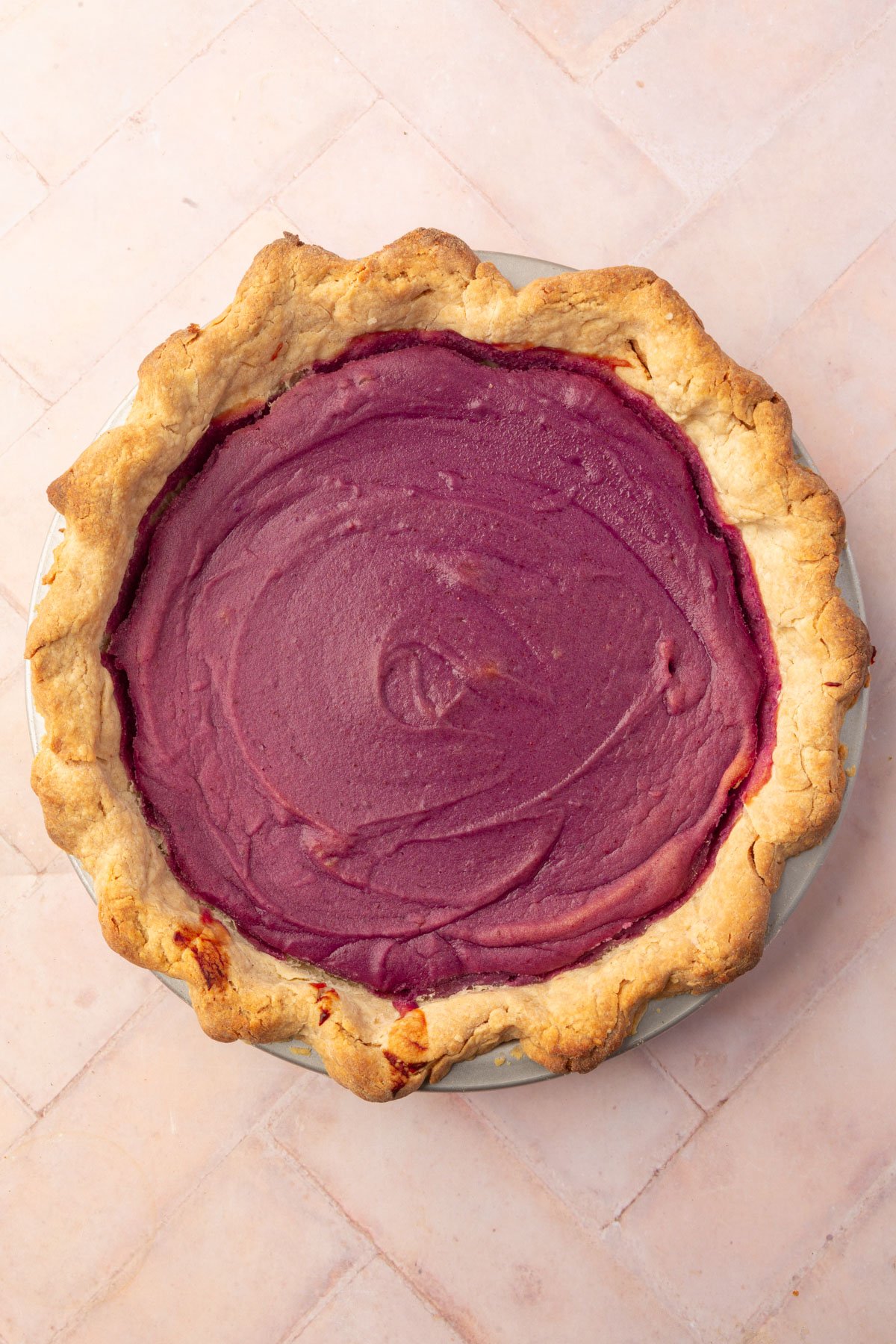 The baked purple sweet potato pie with a lightly browned gluten-free crust, featuring the rich purple filling.