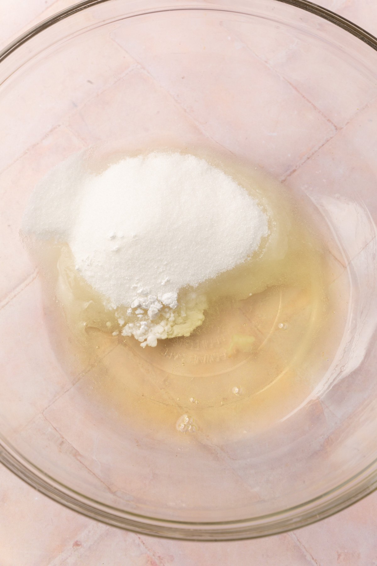 A bowl with granulated sugar, cream of tartar and egg whites to before mixing together.
