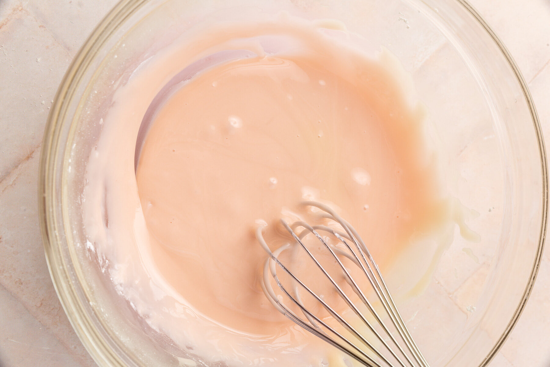 Image of mixing bowl with pop tart frosting mix and whisk in the bowl.