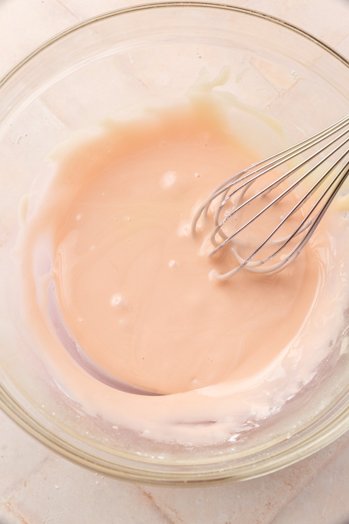 Image of mixing bowl with pop tart frosting mix and whisk in the bowl.