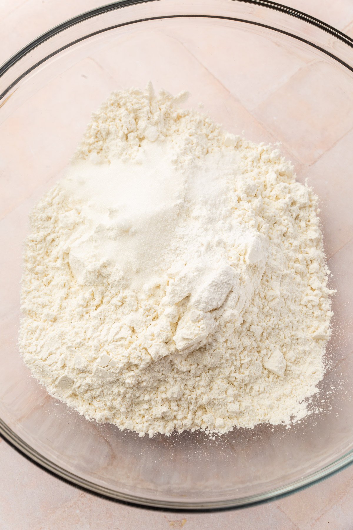 Mixing bowl with gluten-free flour, sugar, salt and baking powder not yet mixed together.