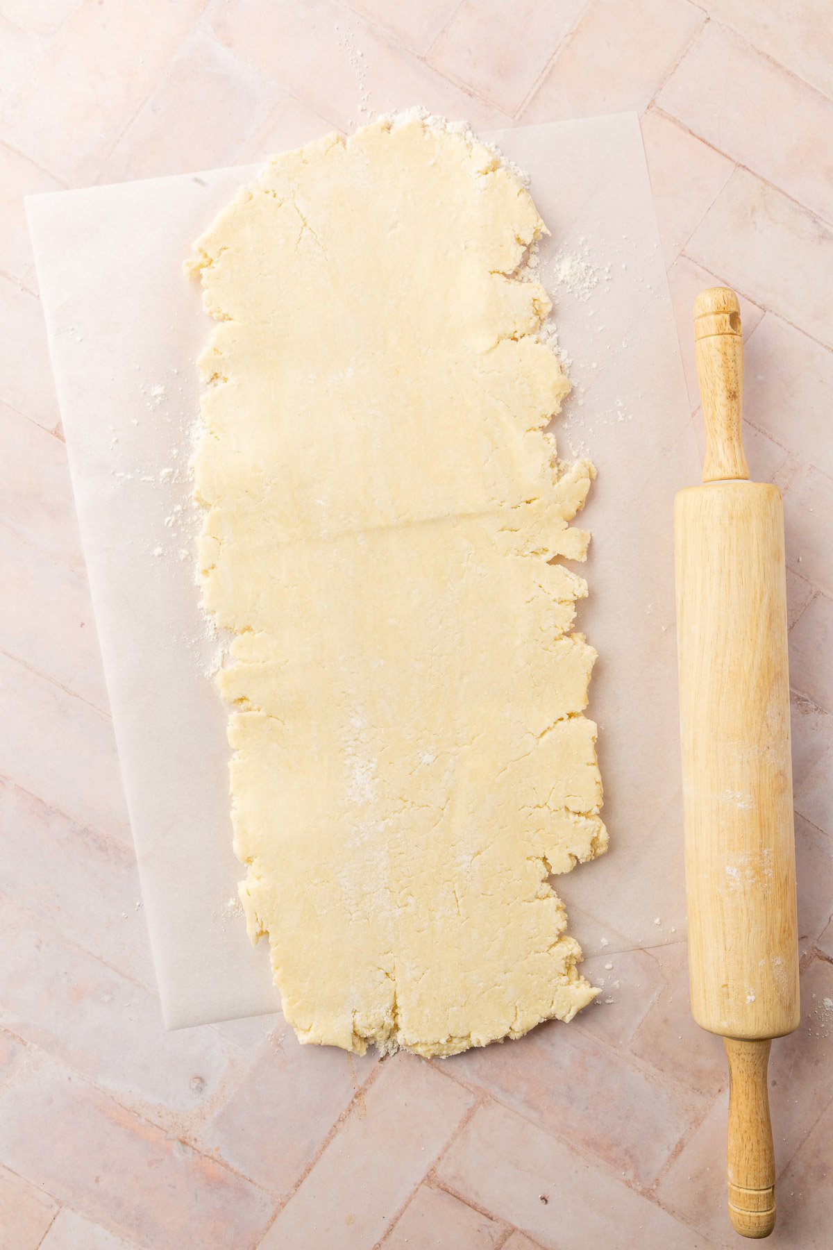 Image of pop tart dough on parchment paper with rolling pin next to it.
