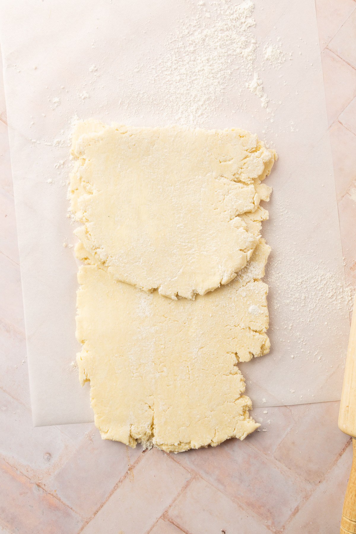 Image of pop tart dough partially rolled out on parchment paper.
