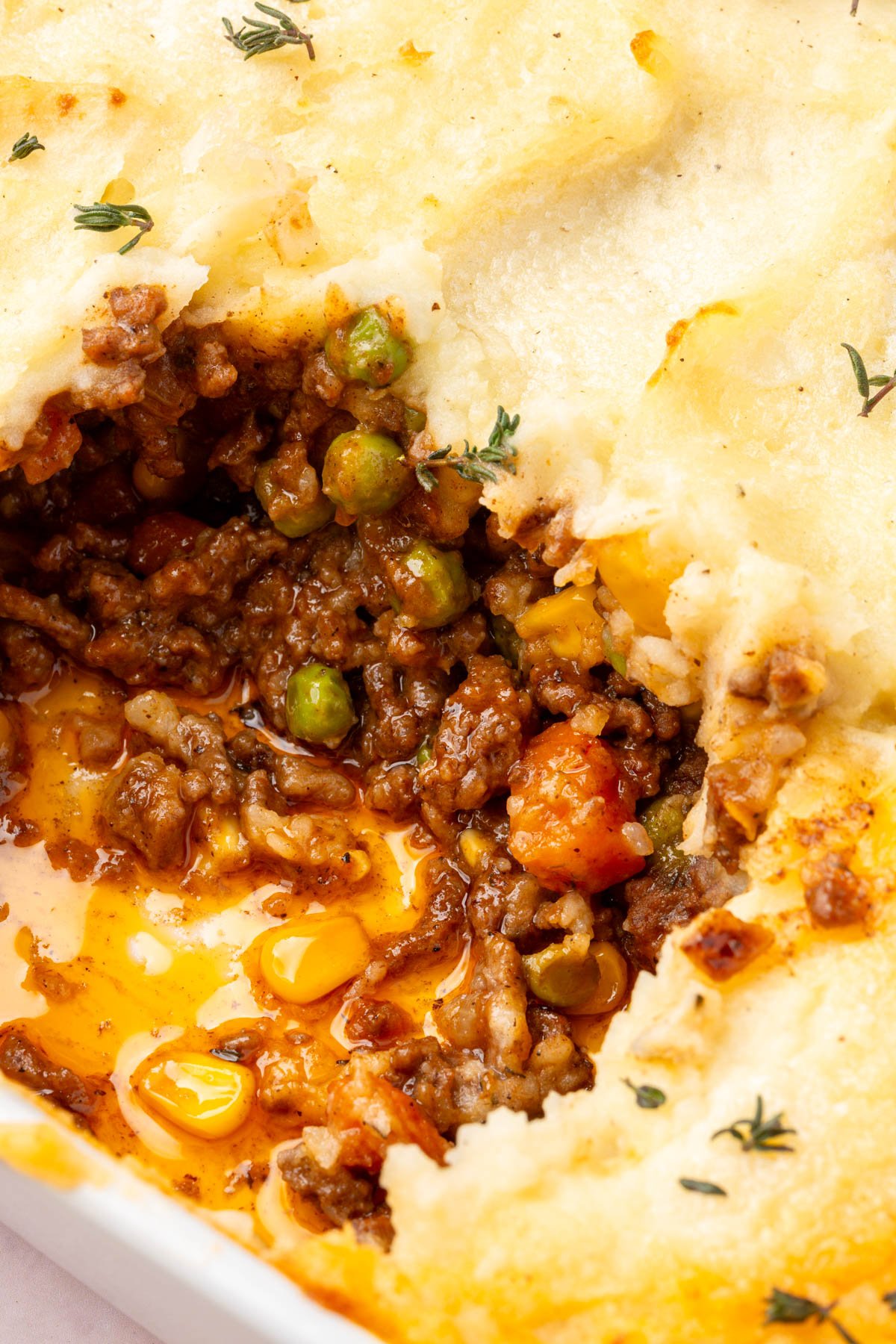 Close up image of shepherd's pie with a piece of it gone to reveal the inside of the meal.