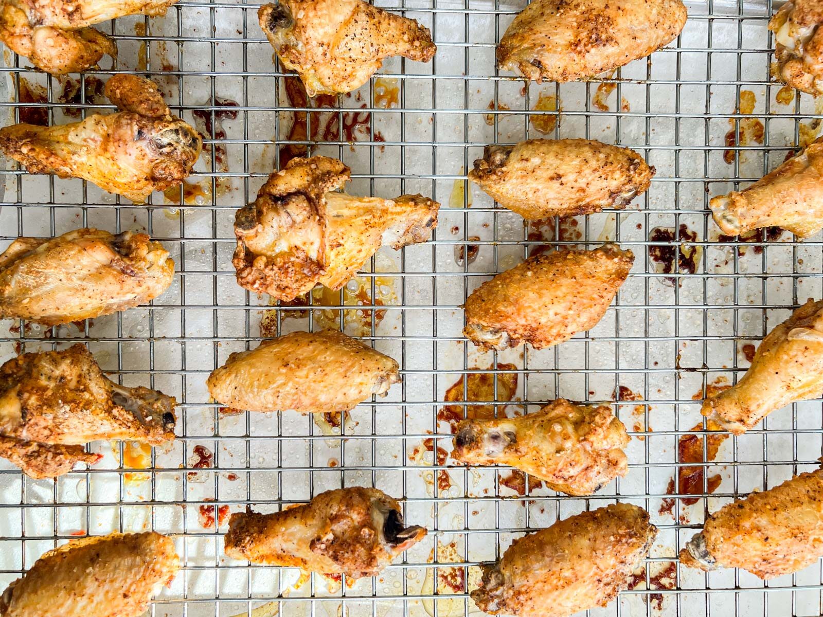 Cooked chicken wings on a wire rack over a baking sheet.