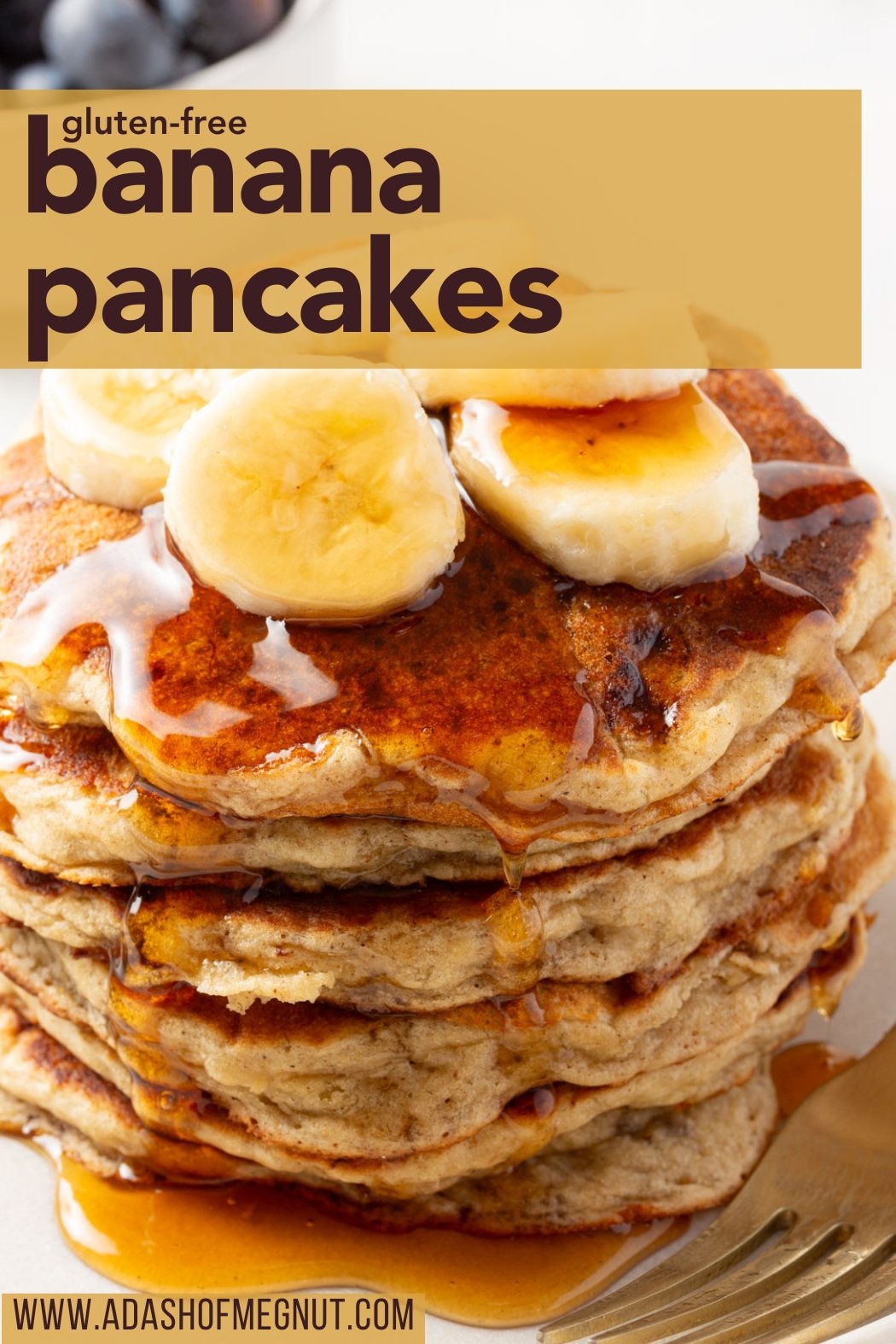 Stack of gluten-free banana pancakes topped with banana slices and drizzled with syrup, with "gluten-free banana pancakes" in bold brown text on a gold background and "www.adashofmegnut.com" at the bottom.