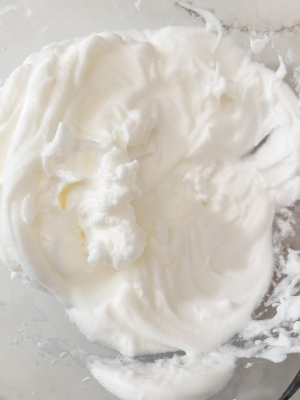 Close-up of stiffly whipped egg whites with peaks holding their shape.