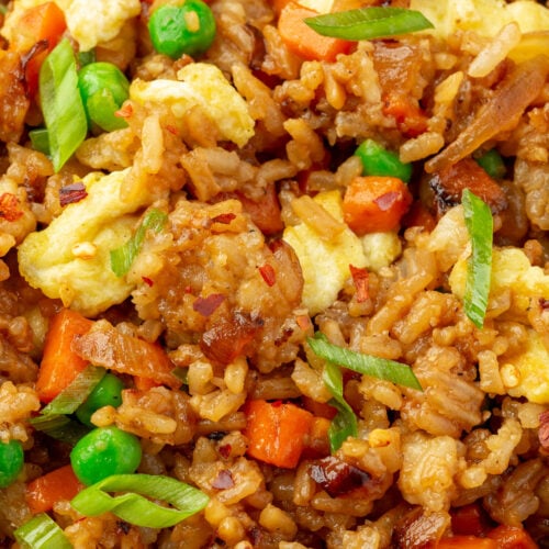 Extreme close-up of gluten-free fried rice with crispy rice, scrambled eggs, carrots, and peas