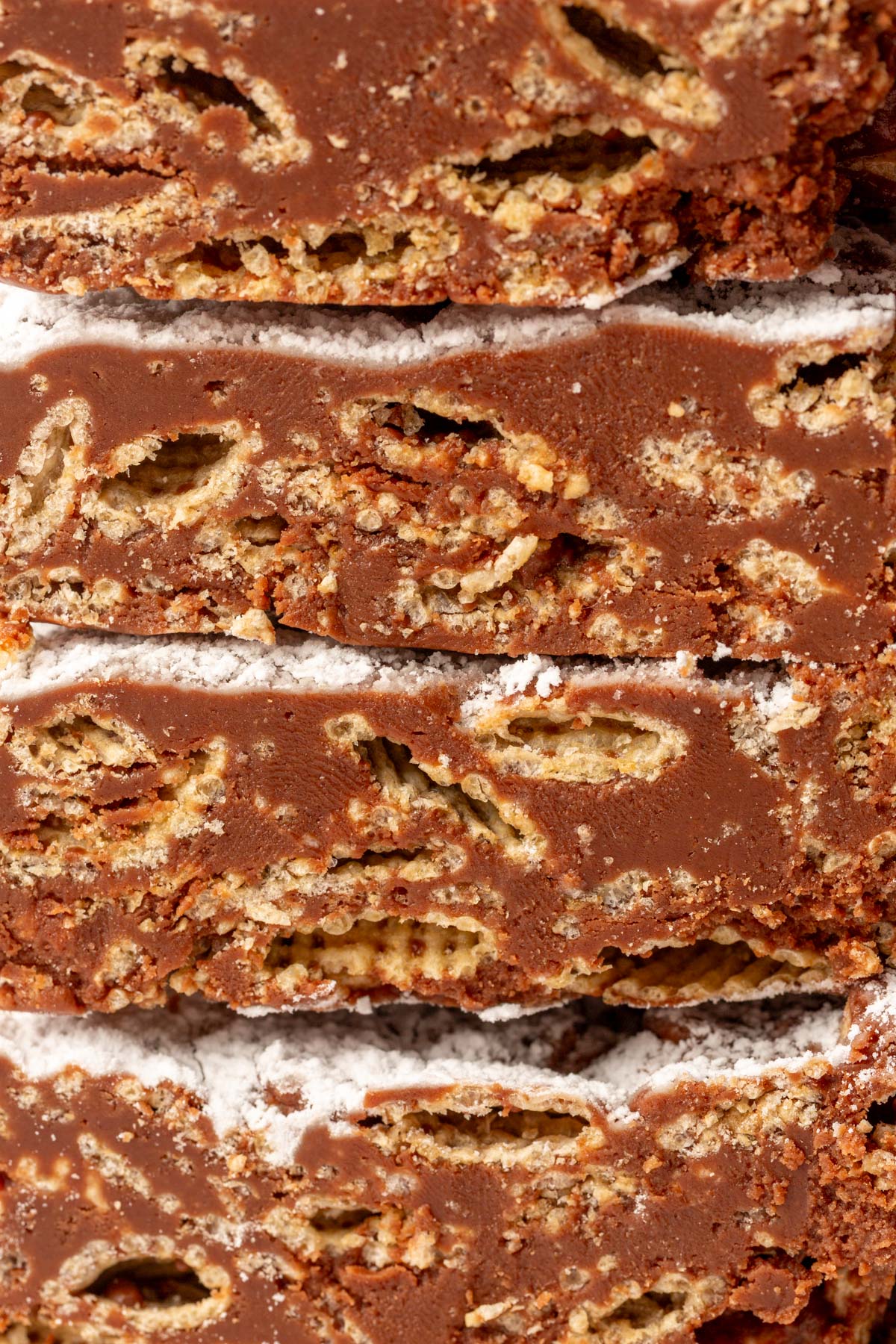 Tightly stacked puppy chow bars showing neat layers of cereal and smooth chocolate coating.