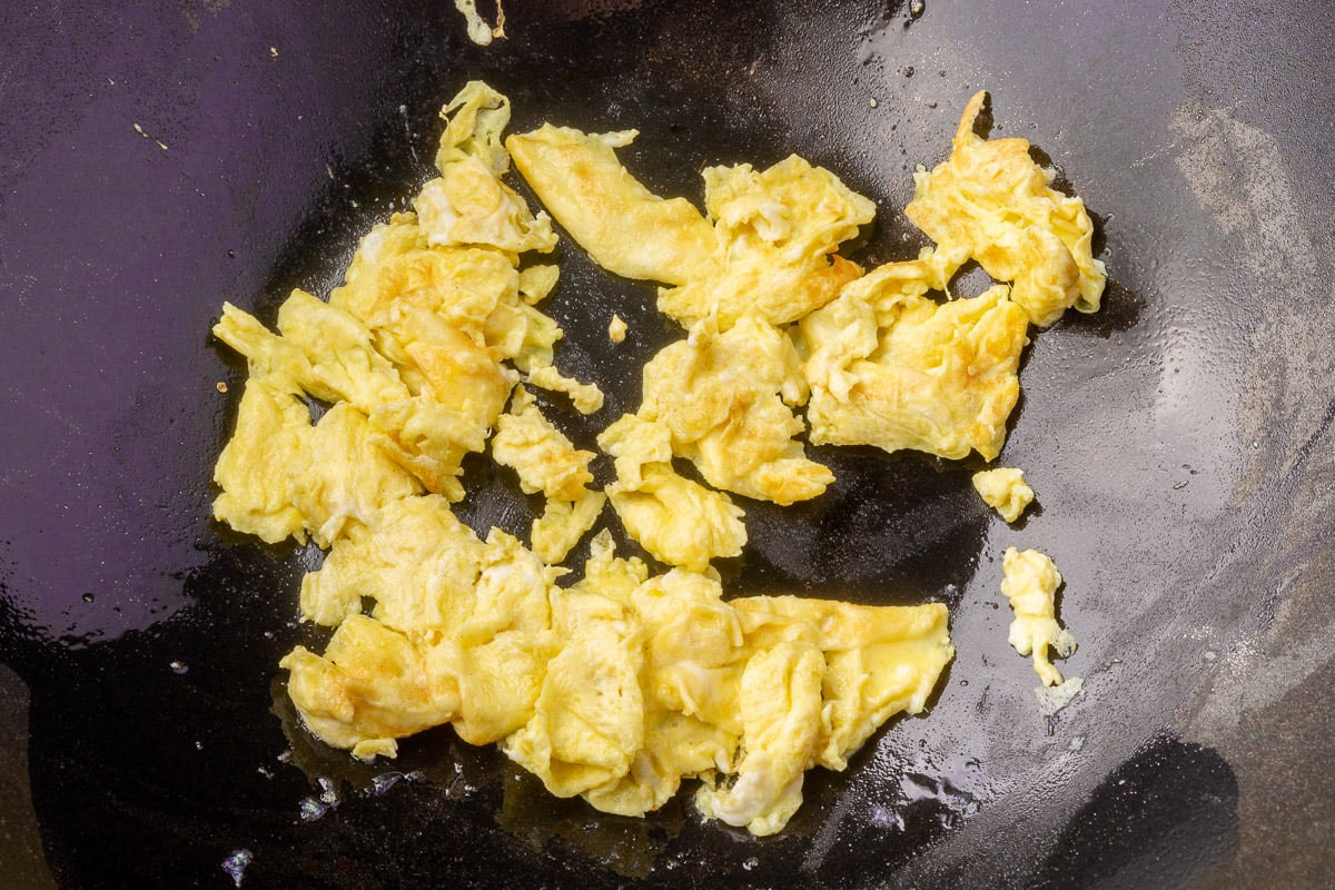 Scrambled eggs cooked in a wok, ready to be added to gluten-free fried rice.
