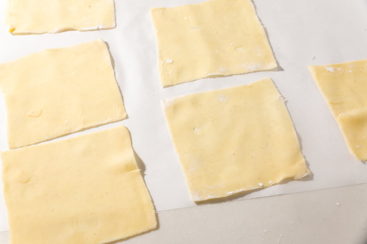 Homemade gluten-free wonton wrappers cut into even squares, ready to fill and cook.