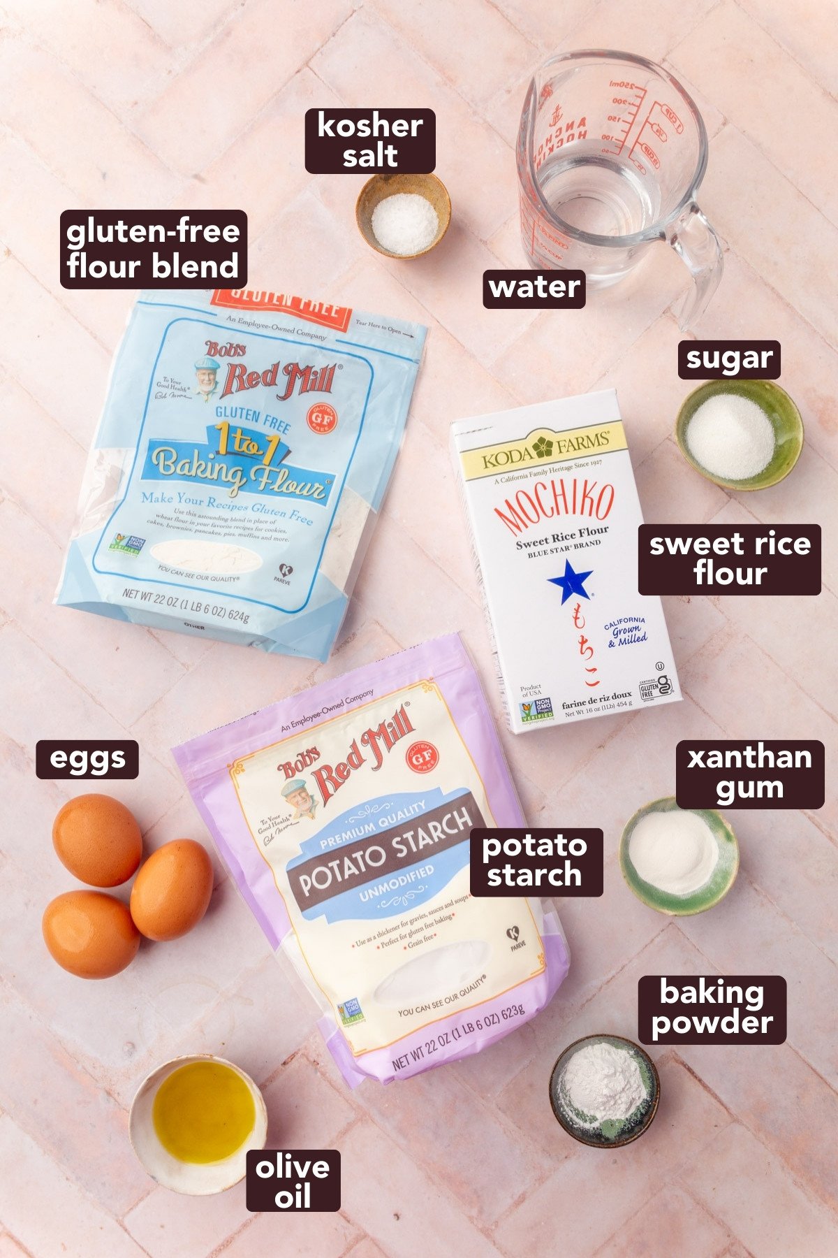 Overhead view of ingredients for homemade gluten-free wonton wrappers, including flours, potato starch, xanthan gum, eggs, olive oil, sugar, salt, and water.