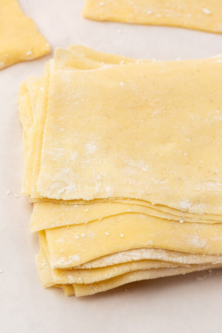 Close-up of a stack of homemade gluten-free wonton wrappers with a light dusting of flour.