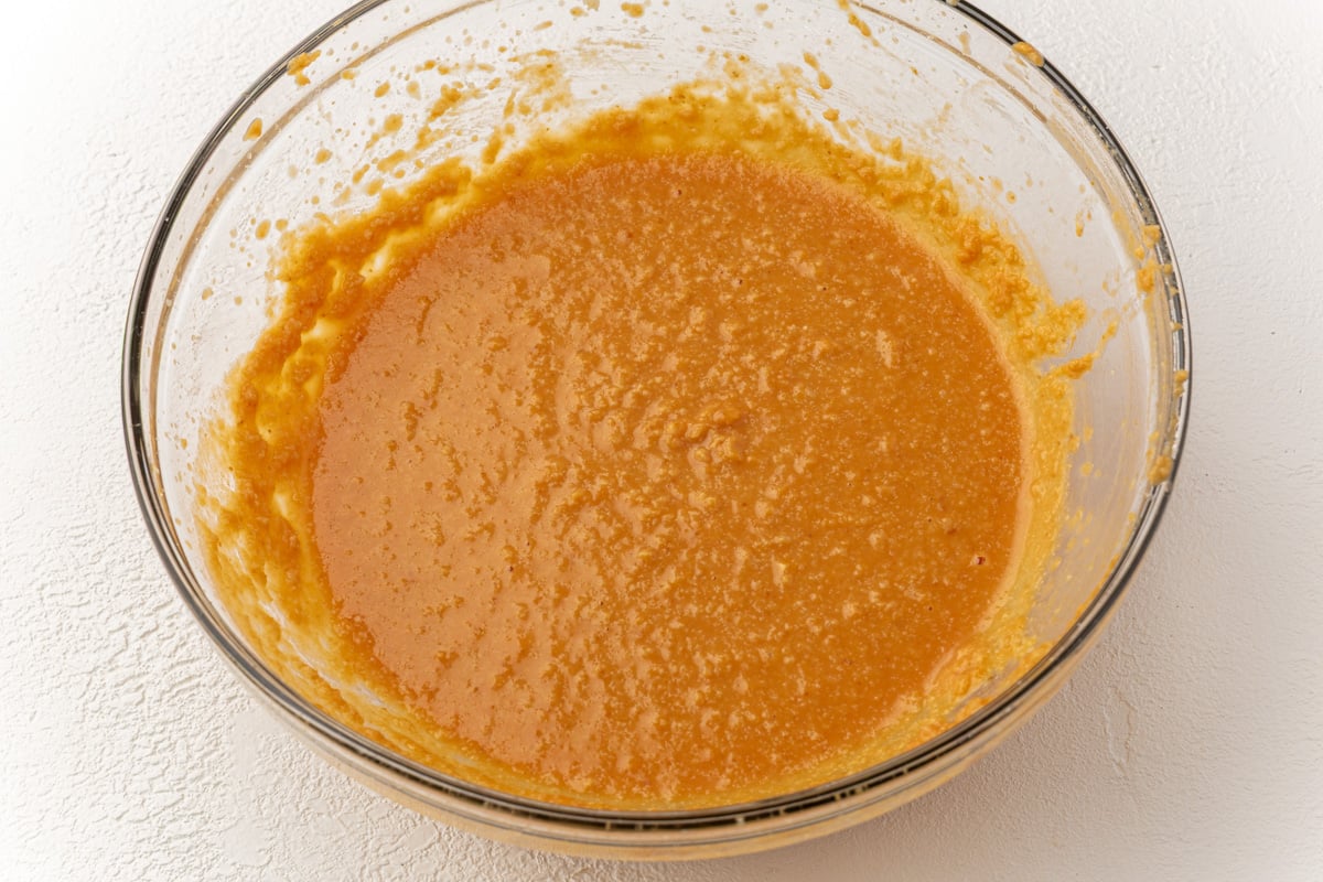 Smooth orange pumpkin batter after mixing wet ingredients for gluten-free pumpkin coffee cake.