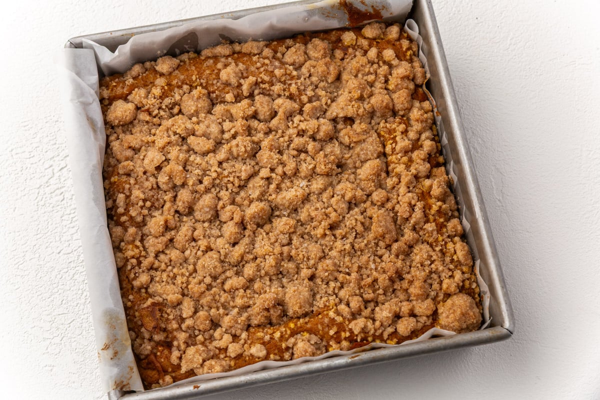 Gluten-free pumpkin coffee cake just out of the oven with golden brown streusel topping in baking pan.