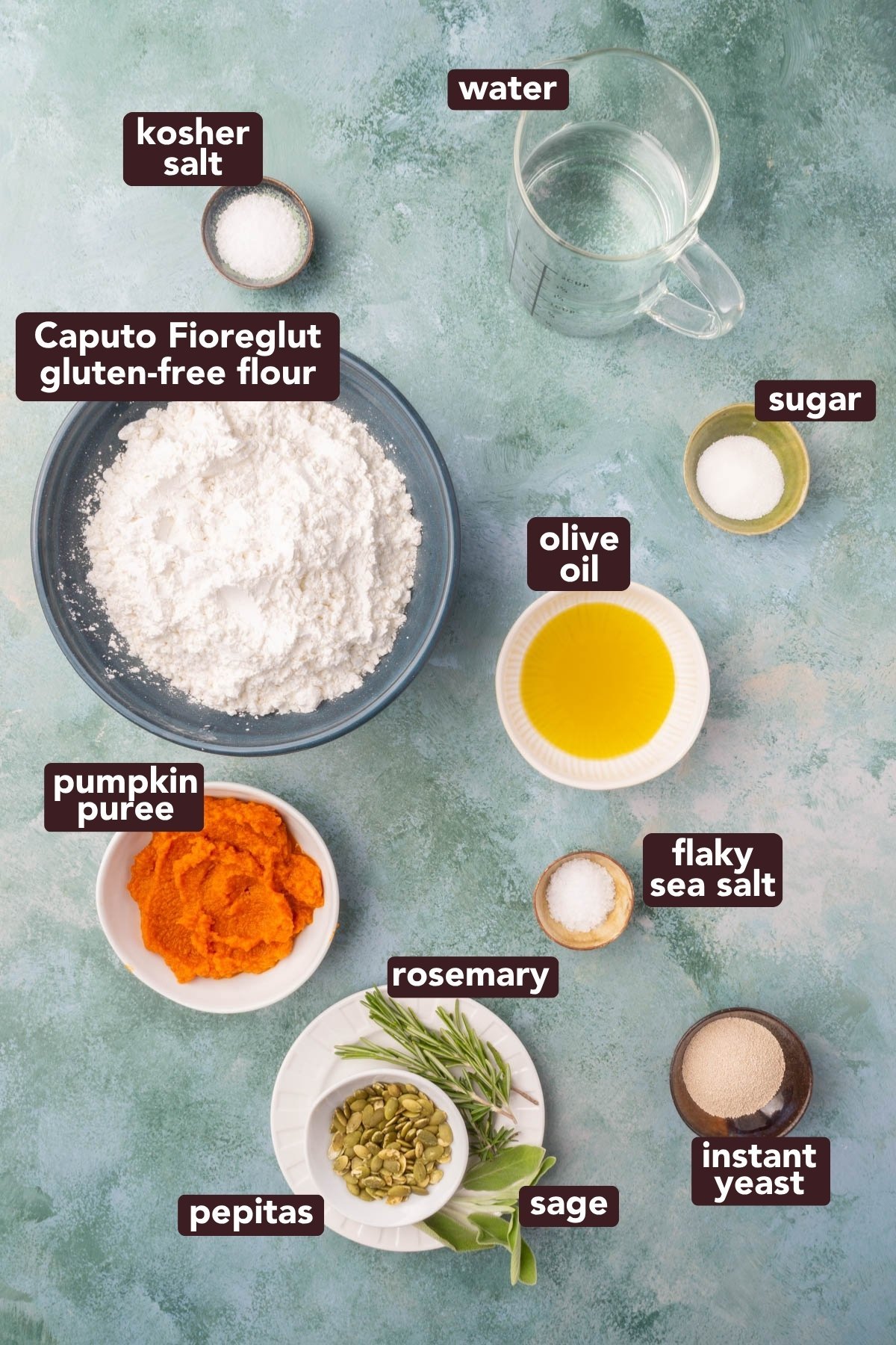 Flat lay of ingredients for gluten-free pumpkin focaccia including flour, pumpkin puree, olive oil, yeast, and herbs.