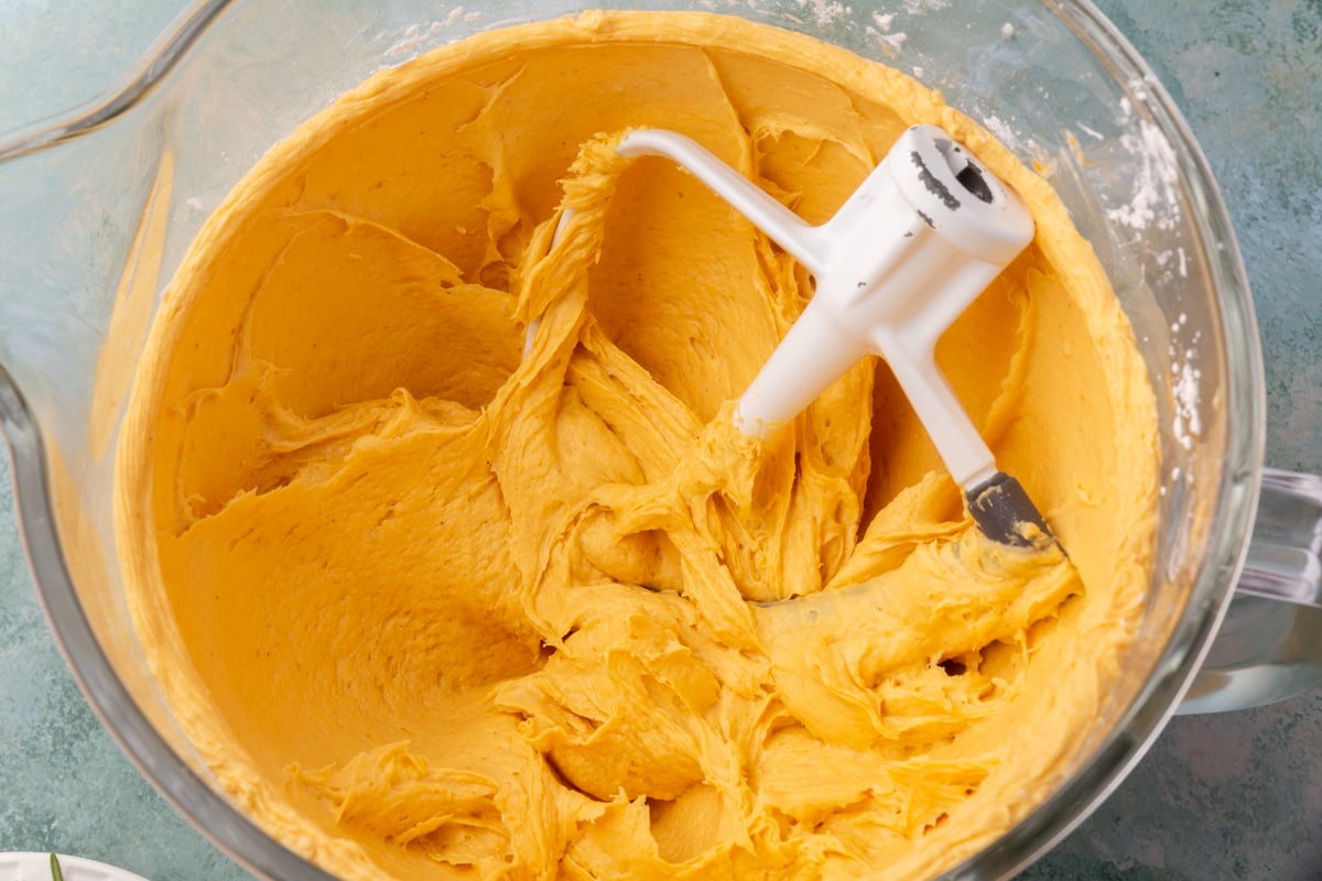 Mixed pumpkin focaccia dough in a stand mixer bowl with paddle attachment.