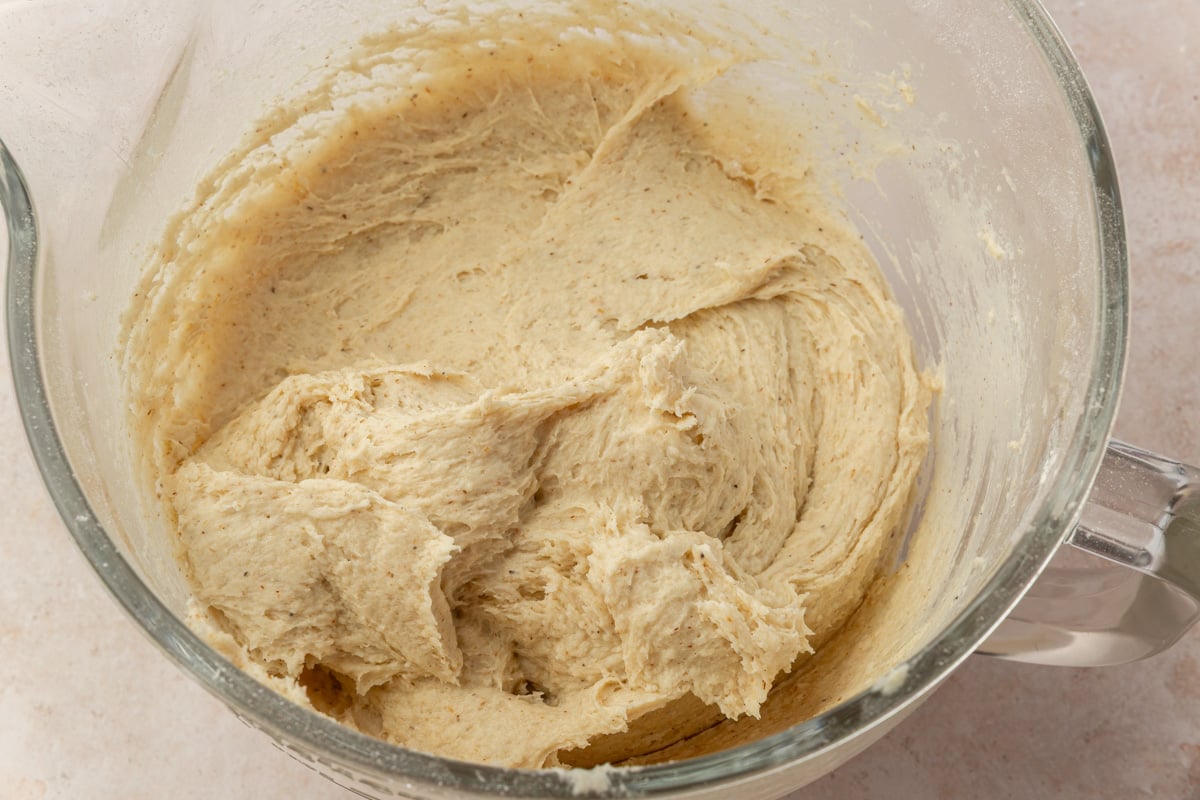 Soft gluten-free cinnamon roll dough in a mixing bowl after mixing.