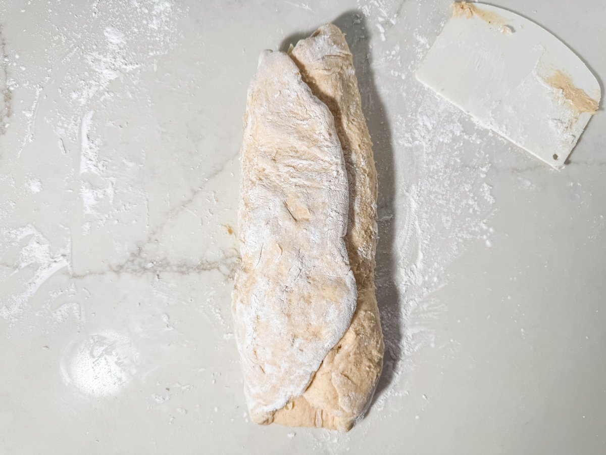 Gluten-free dough folded into thirds showing letter fold lamination technique.