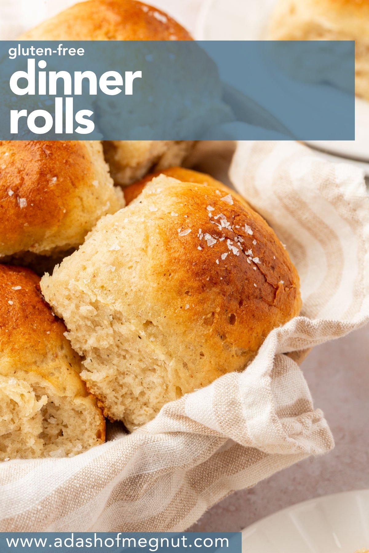 Basket of golden gluten-free dinner rolls with a striped towel and text overlay that reads โGluten-Free Dinner Rolls.โ