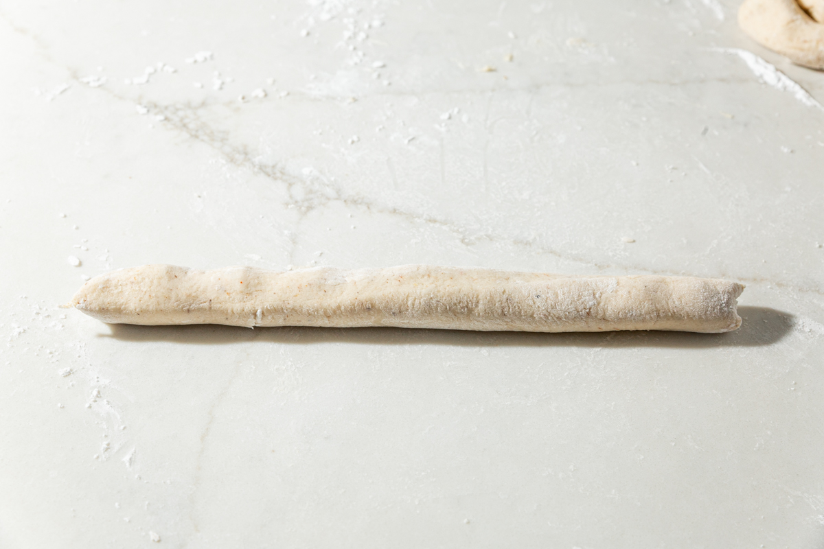 A long, thin strip of gluten-free dough rolled into a rope for shaping garlic knots.