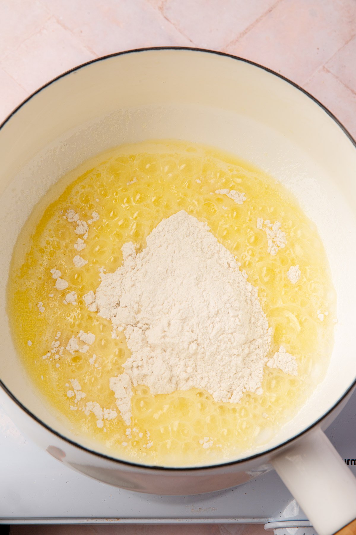 Gluten-free flour added to melted butter in a saucepan to begin forming the roux.