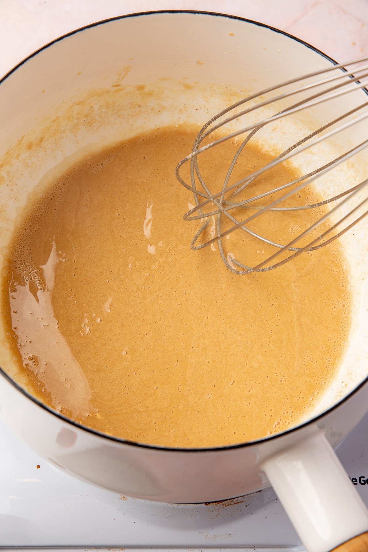 Dark brown gluten-free roux in a saucepan, ready for gravies or stews.