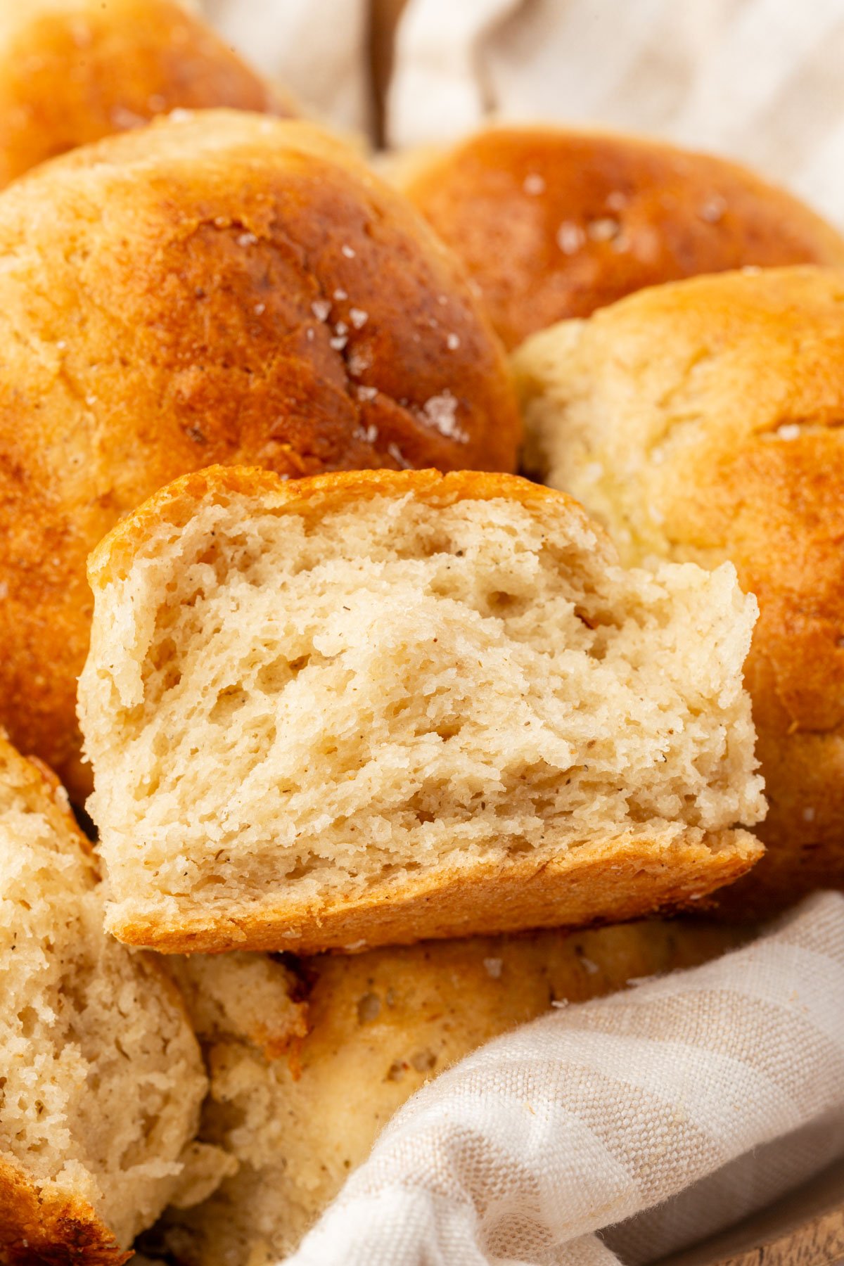 Close-up of the inside texture of a gluten-free dinner roll showing a soft, airy crumb.