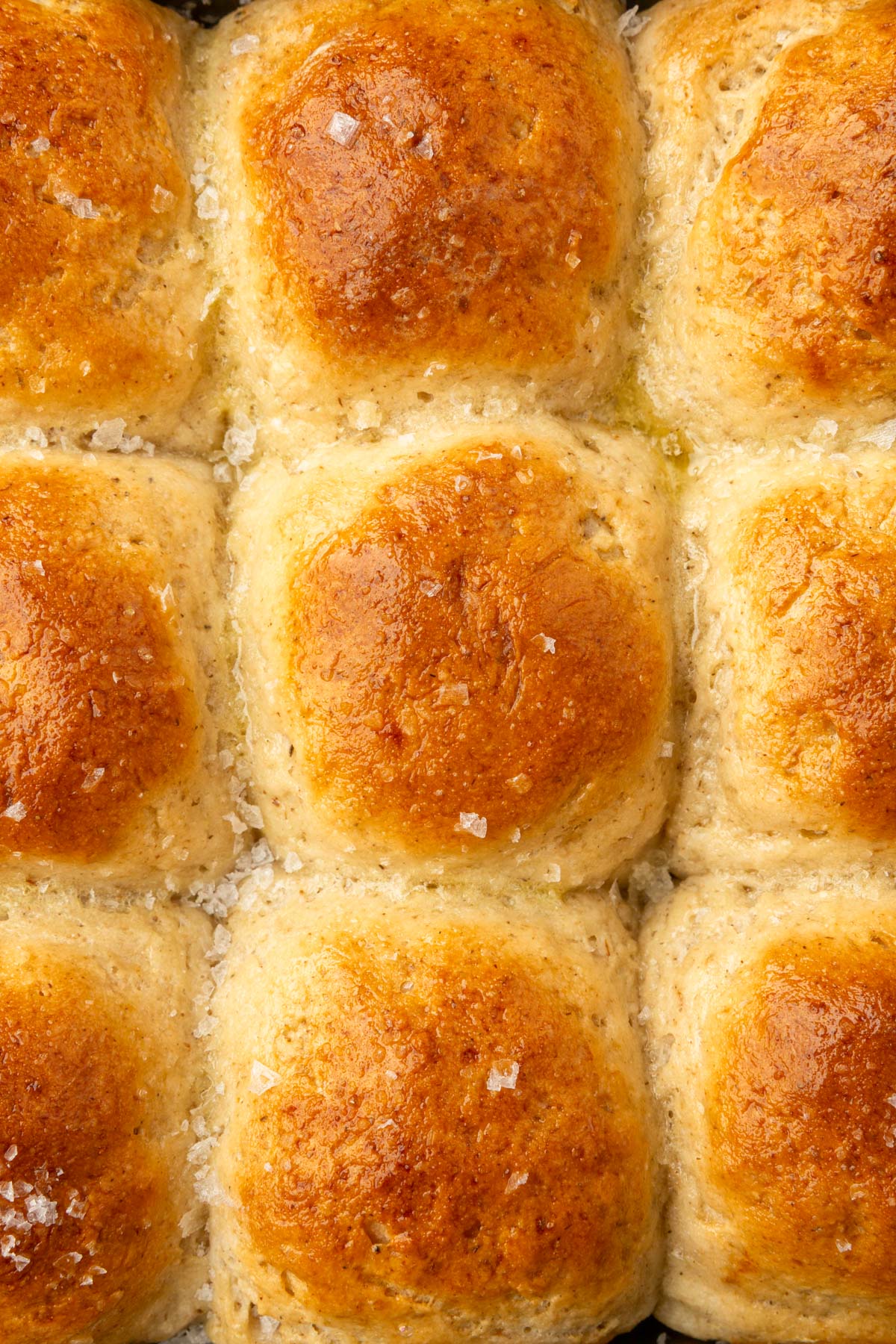 Overhead view of gluten-free dinner rolls with flaky sea salt glistening on top.