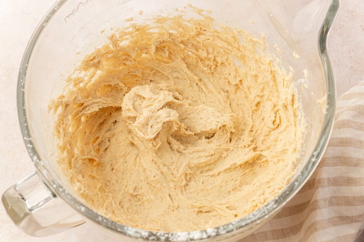 Soft, sticky gluten-free dinner roll dough after mixing in a large glass bowl.