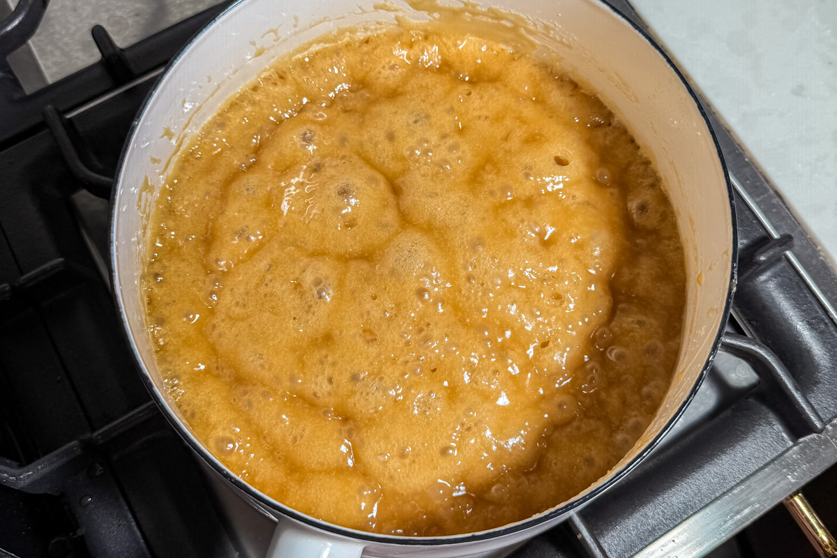 Smooth golden caramel sauce bubbling in saucepan after boiling butter and brown sugar for 3 minutes.
