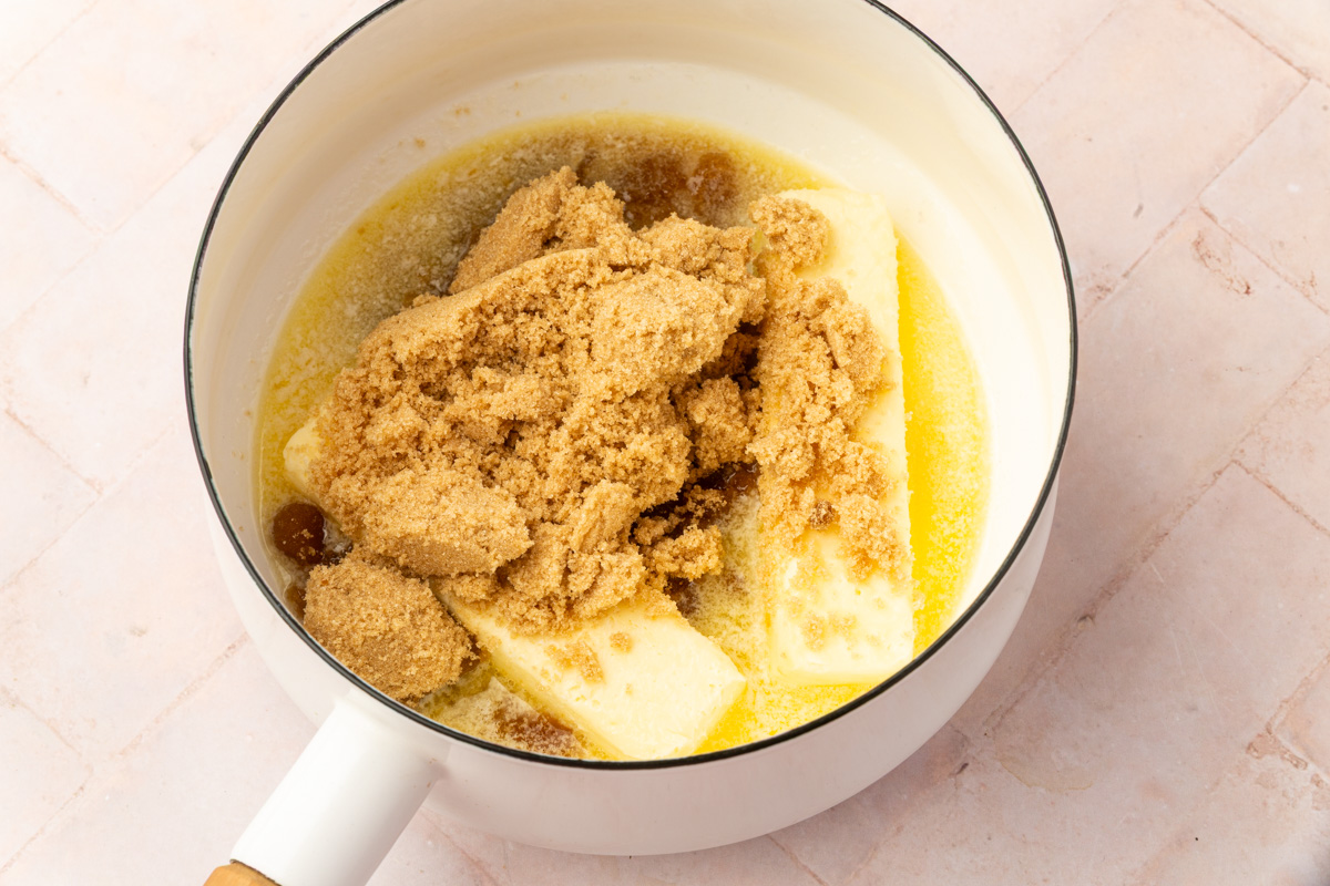 Melted butter and brown sugar in white saucepan before making caramel for pretzel bark.