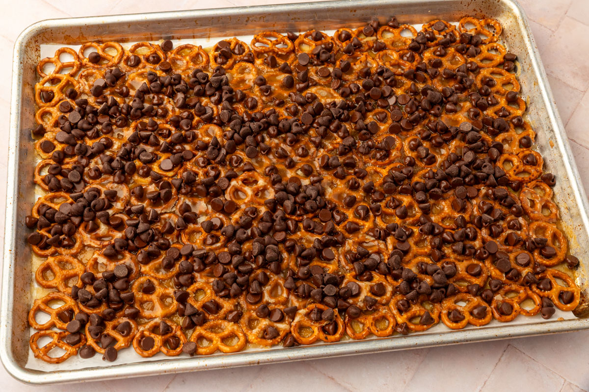 Semisweet chocolate chips sprinkled over hot caramel-covered pretzels before melting.
