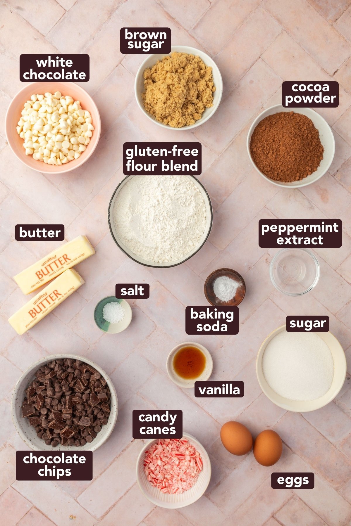 Ingredients for gluten-free chocolate peppermint cookies including flour, cocoa powder, butter, sugars, eggs, chocolate chips, white chocolate, and crushed candy canes with text labels.