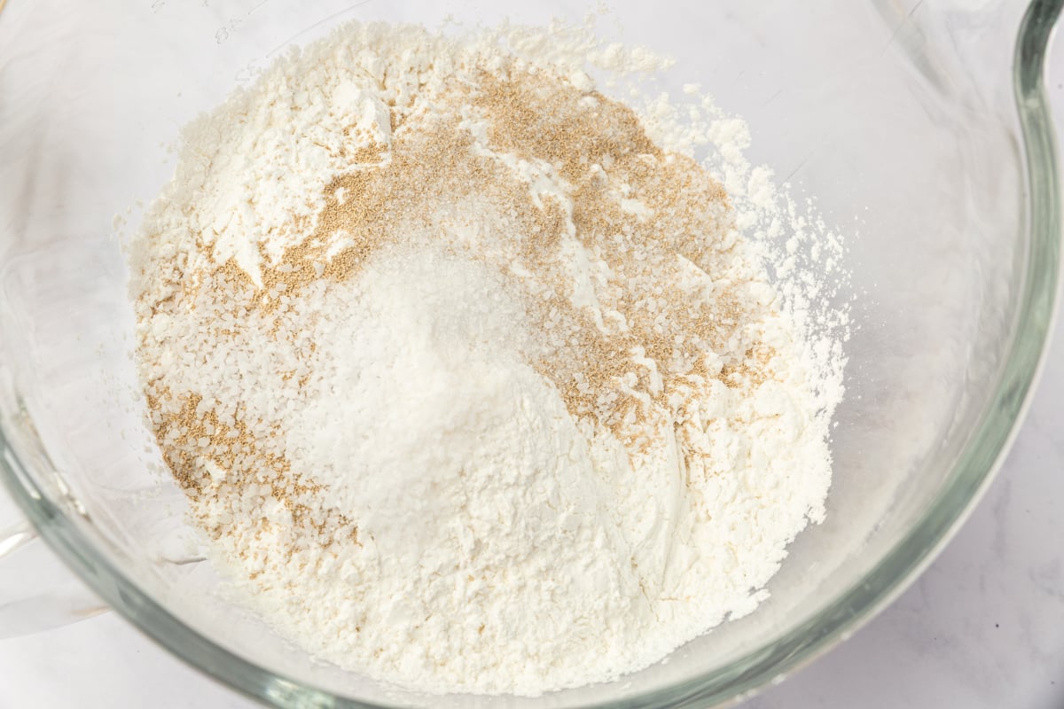 Dry ingredients for gluten-free Christmas tree focaccia in glass bowl including Caputo flour, yeast, sugar, and salt.