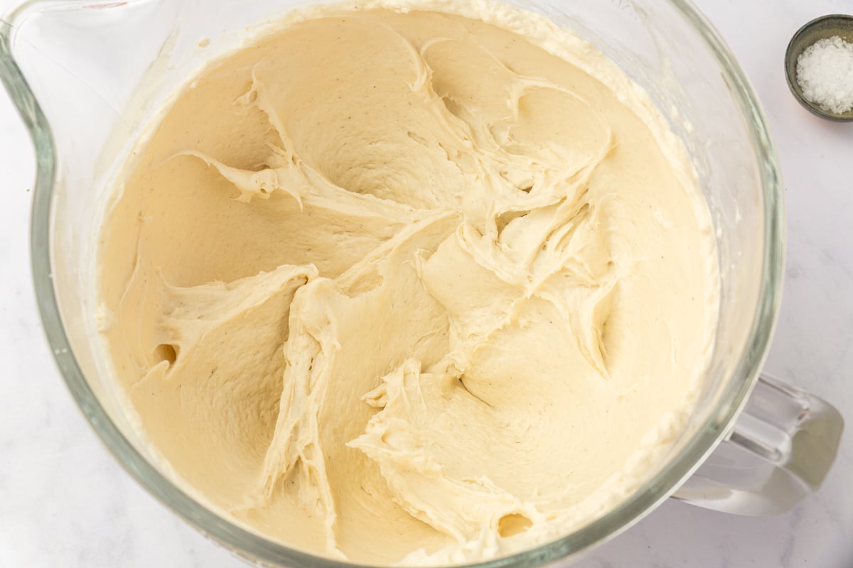 Thick sticky gluten-free focaccia dough mixed in stand mixer bowl showing proper consistency.