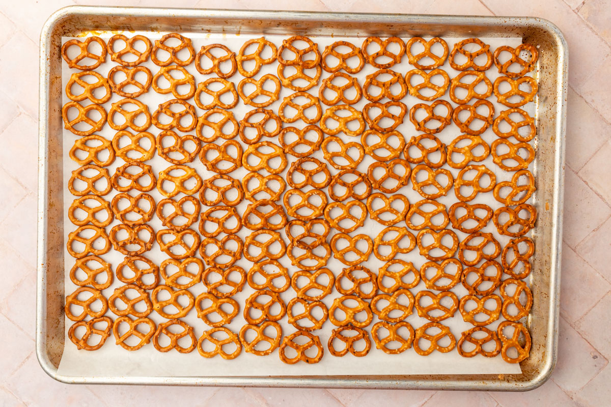 Gluten-free pretzels arranged in single layer on parchment-lined baking sheet ready for caramel.