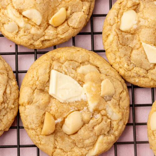 Gluten-free white chocolate macadamia nut cookies cooling on a wire rack.