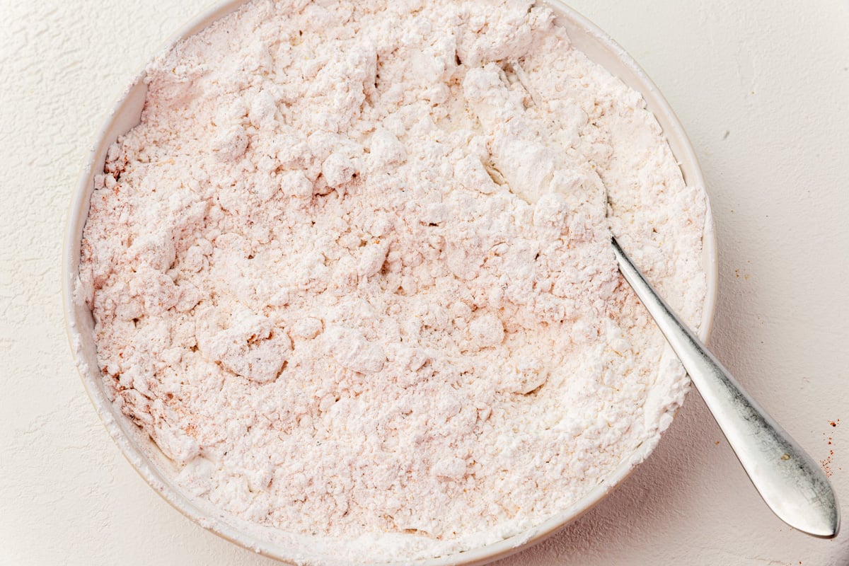 Gluten-free flour mixture with craggy bits formed from buttermilk marinade.