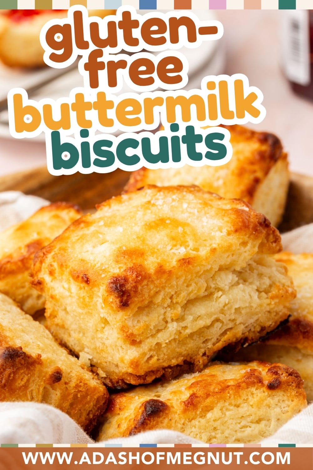 A basket of golden, flaky gluten-free buttermilk biscuits is shown close up. Text overlay reads “gluten-free buttermilk biscuits.” Website www.adashofmegnut.com appears at the bottom.
