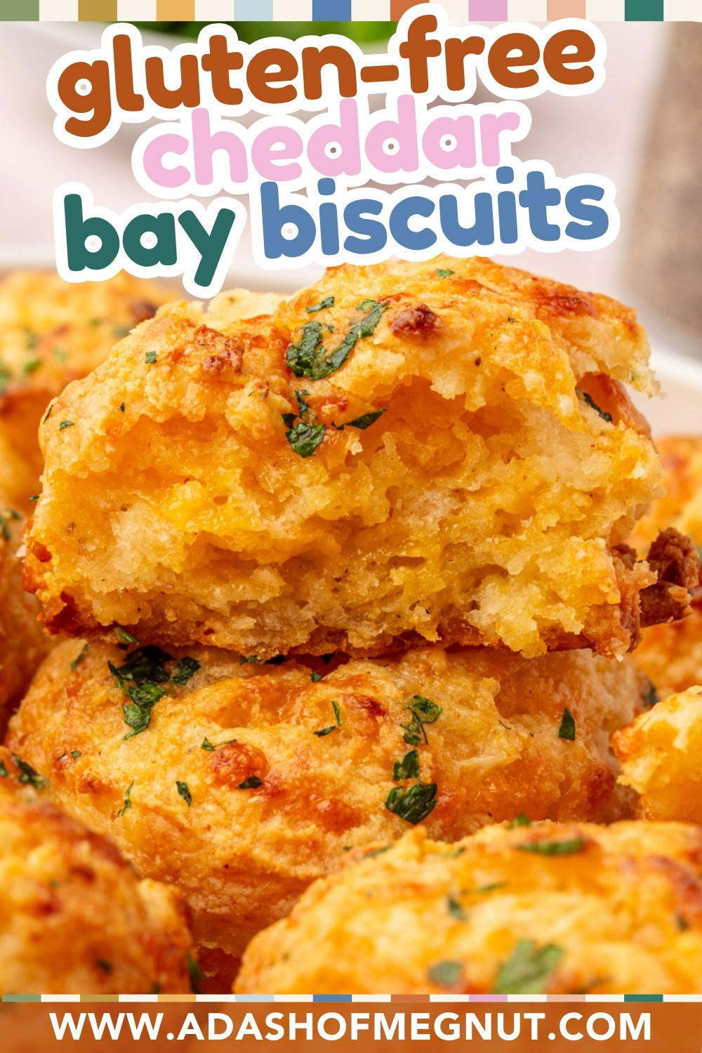 Close-up of golden, fluffy gluten-free cheddar bay biscuits topped with herbs, with one biscuit split open to show its cheesy, moist interior. Text reads gluten-free cheddar bay biscuits and www.adashofmegnut.com.