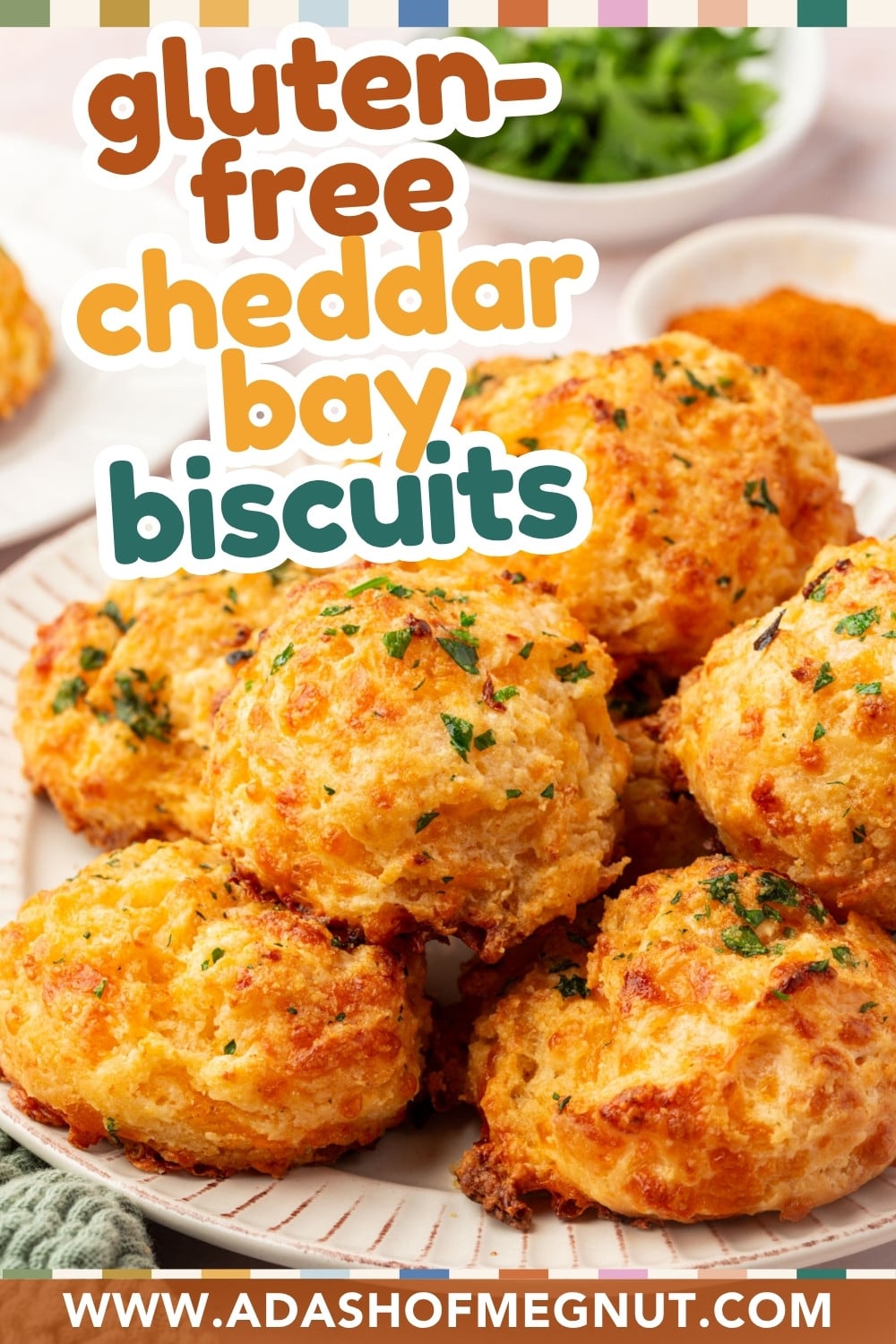 A plate of golden, gluten-free cheddar bay biscuits garnished with herbs. Text on the image reads gluten-free cheddar bay biscuits and a website URL appears at the bottom: www.adashofmegnut.com.