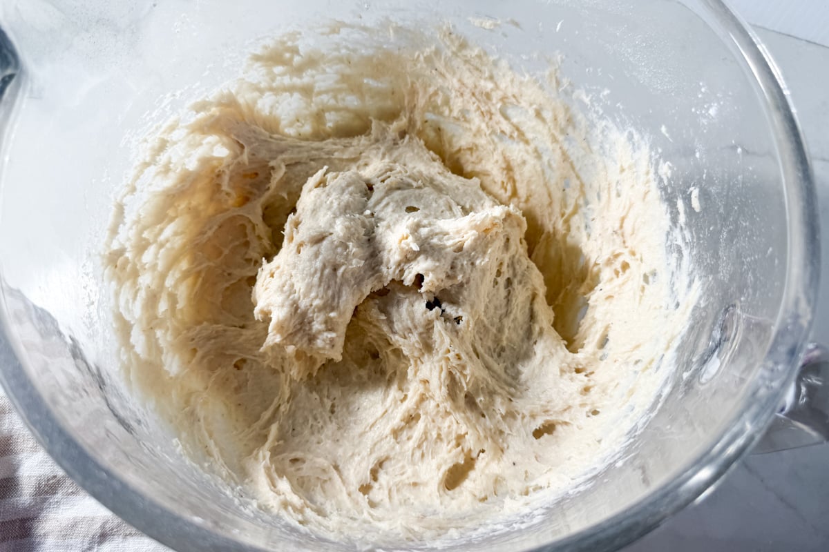 Sticky, unbaked gluten-free dough in a glass mixing bowl.