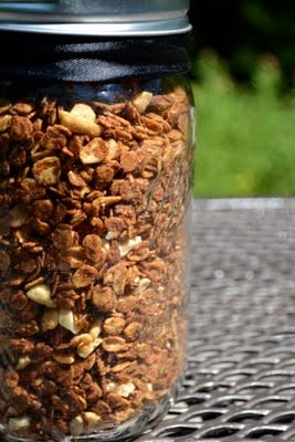 a mason jar of peanut butter granola with a black ribbon tied around it.