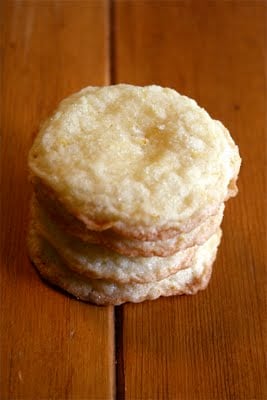 A stack of lemon almond cookies on a wood table. 