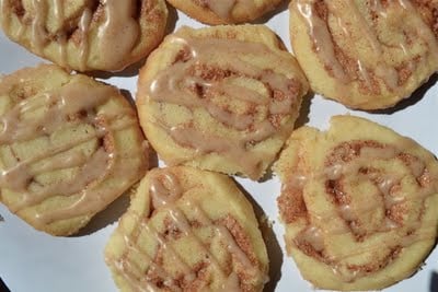 A plate of cinnamon roll cookies with cinnamon glaze.